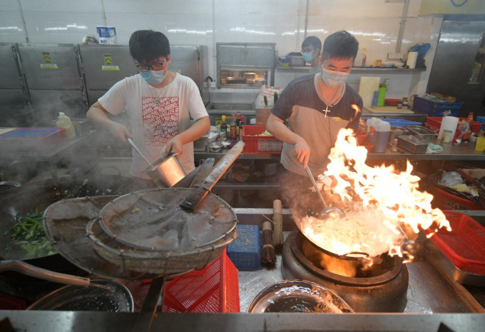 学生及义工在饭堂煮食。