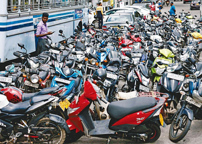 在斯里蘭卡首都科倫坡，昨日有大批電單車在等候入油。