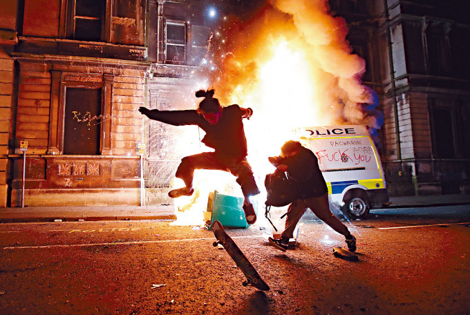 布里斯托示威者周日焚燒一輛警車，一名示威者還在現場踩滑板。　