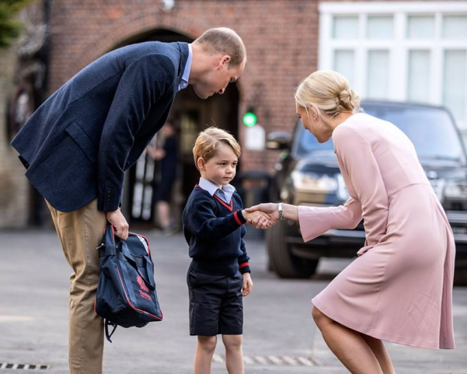 乔治王子由爸爸威廉王子陪伴上学，并与校长握手打招呼。