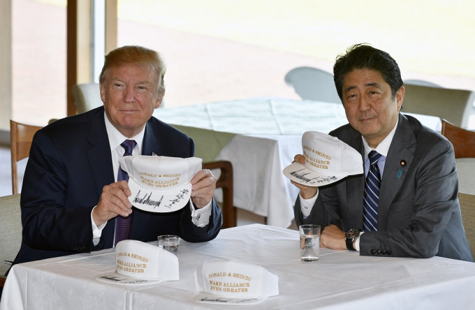 安倍與特朗普互相在白帽上簽名。AP圖片