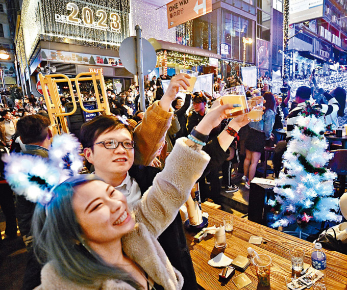 市民聚集兰桂坊，在零时零分高举酒杯迎接新一年。
