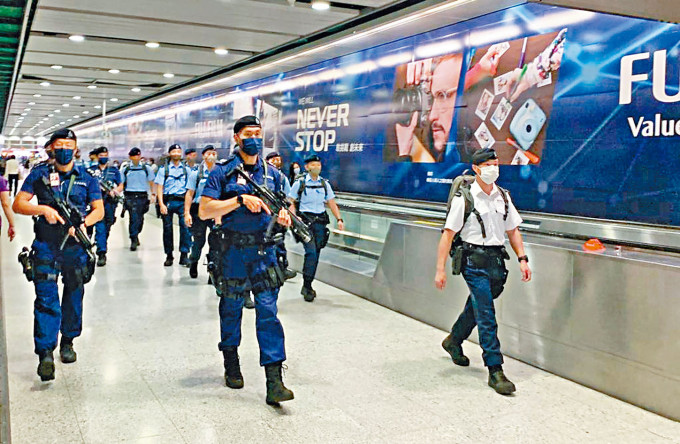 机场特警持枪在港铁站内巡逻。