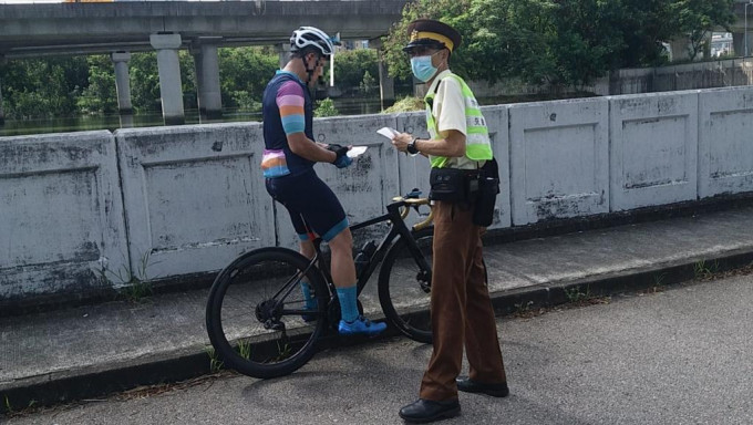执法人员向骑踏单车人士派发宣传单张。图:警方提供