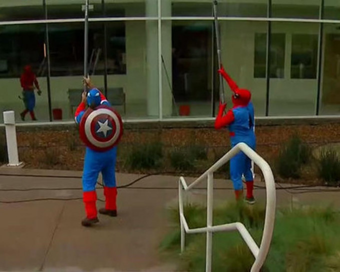 壯男打扮成蜘蛛俠和美國隊長抺窗，為病童添歡樂。網圖