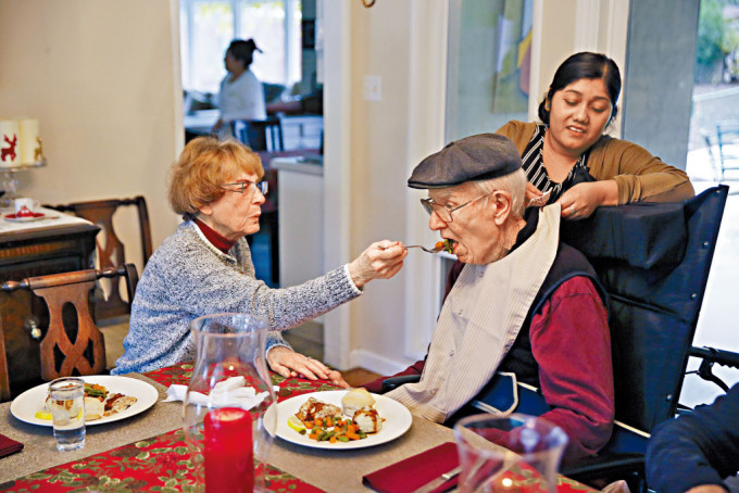 一名婦人在加州的護老中心，協助餵食患了阿茲海默症的丈夫。