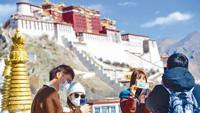 遊客在西藏拉薩布達拉宮前合影。