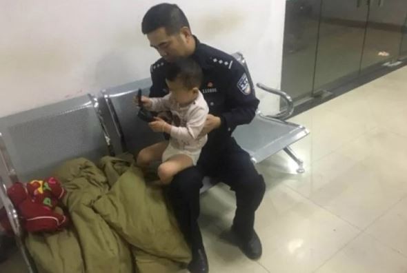 警察照顾两岁男童。网上图片