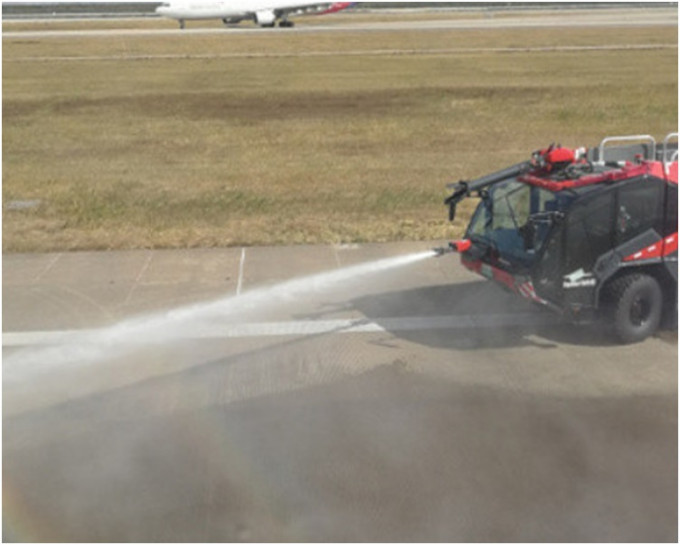 机场消防车向跑道上的达美航空客机起落架洒水降温。网图