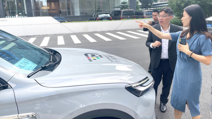 林世雄（右二）听取元戎启行科技有限公司代表介绍自动驾驶服务。政府新闻处
