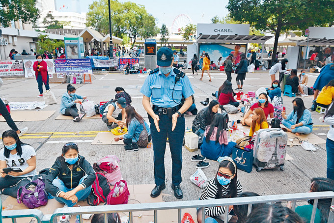 ■警員於中環皇后像廣場一帶，呼籲外傭保持社交距離。