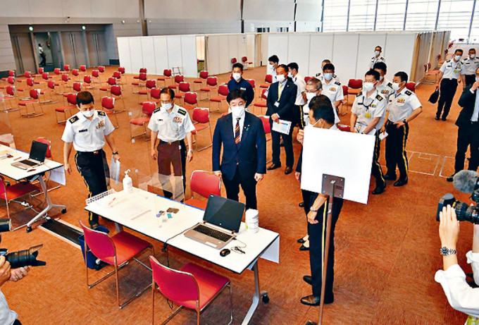 ■日本防衞副大臣中山泰秀(中)周日在大阪接种中心视察。