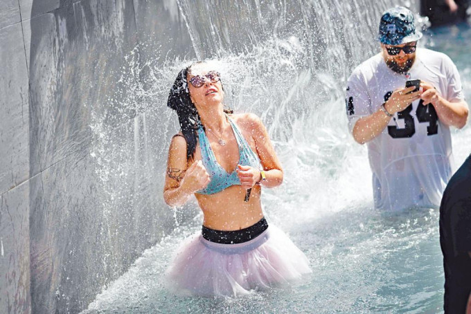 法國西部克利松市周五舉行夏季露天音樂節期間，樂迷以噴泉水涼身。