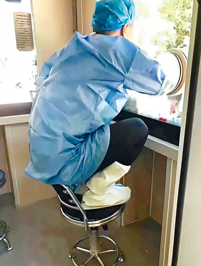 鄭州醫護人員蹲在椅子上採樣。
