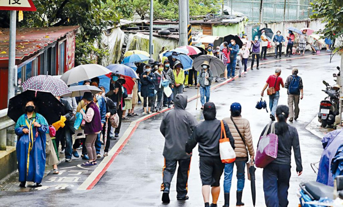 台北居民排队领取快测试剂。