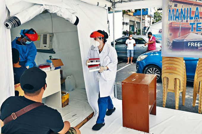 工作人員在馬尼拉臨時醫療中心，收集血液樣本檢驗。