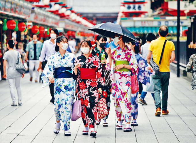 遊客穿和服戴口罩逛東京淺草商店街仲見世通。