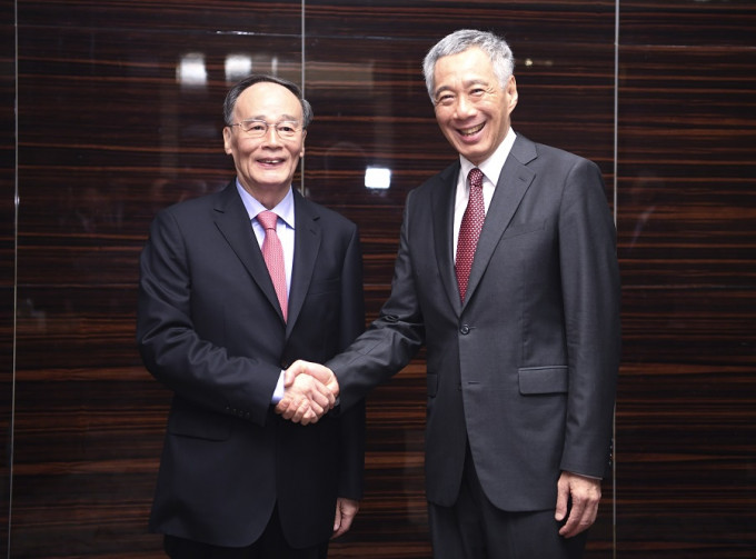 王岐山（左）訪問新加坡，與李顯龍會晤。新華社