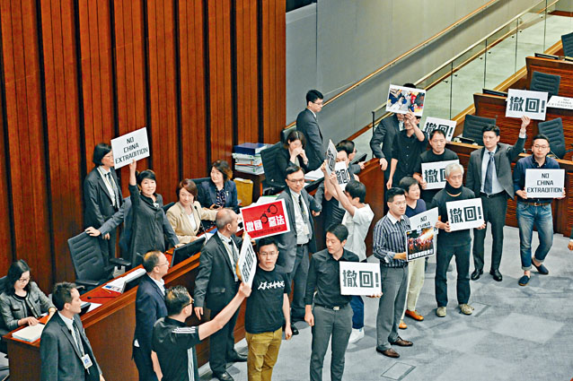 ■立法会内委会主席李慧琼决定不继续会议，泛民则拿出抗议纸牌冲到主席台抗议，高叫「撤回恶法」。