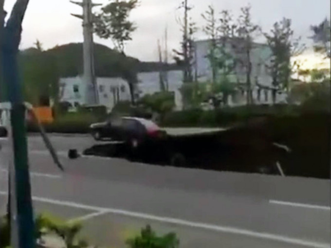 路面出现大面积塌陷，一辆汽车，停在塌陷坑边缘。（网图）
