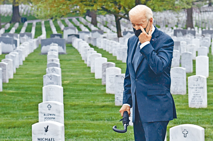 拜登周三到维州阿灵顿国家公墓向在阿富汗战场牺牲的美军致敬，期间他一度用手抹泪。