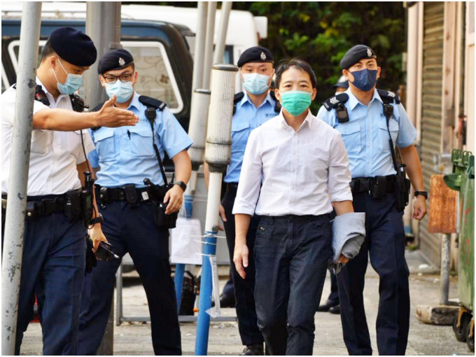 胡志偉由警方陪同下前往殯儀館。