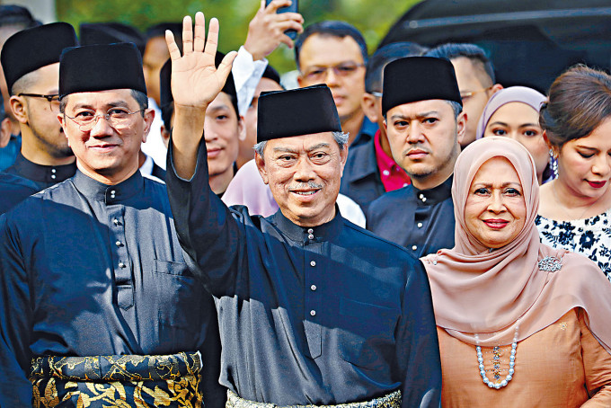 ■马来西亚首相穆希丁（中）去年三月就职时向记者挥手。