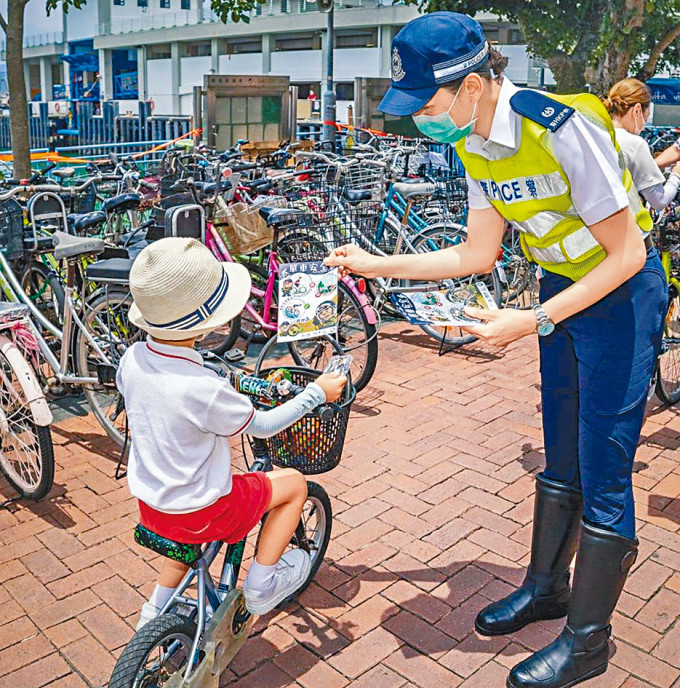 警司黃冰冰（右）去年到長洲向兒童派發宣傳單車安全的單張。