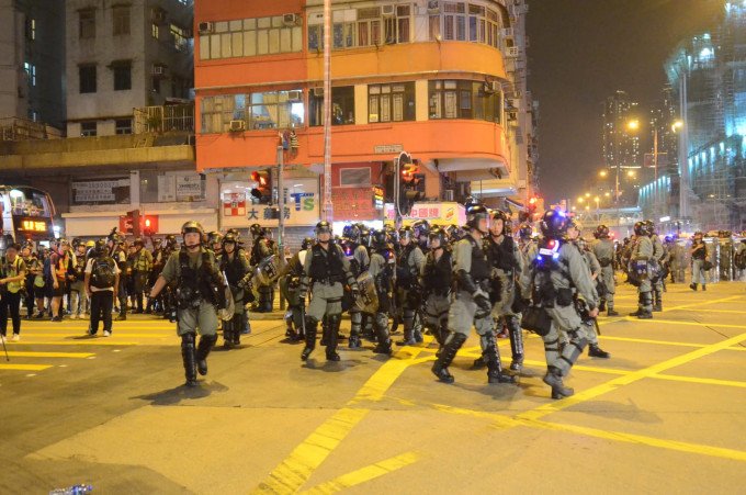 防暴警察驱散示威者。