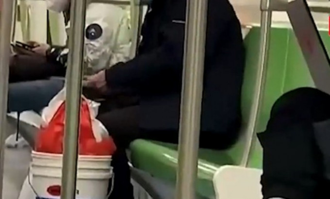 一名男子施施然坐在地鐵車廂座位上磨刀。