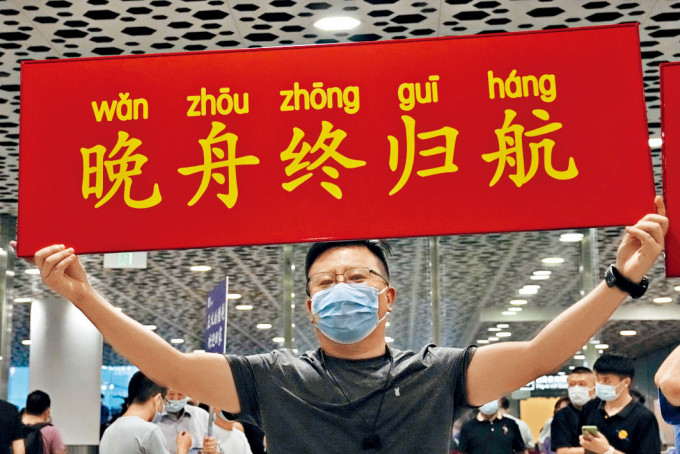 ■大批支持者在深圳机场迎接，高举「晚舟终归航」的标语。