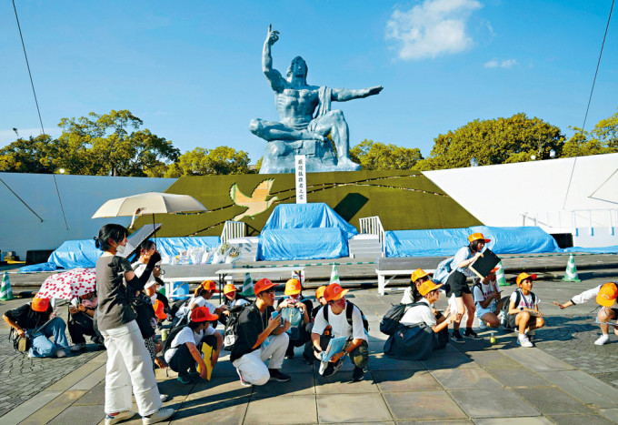 地震警報發出後，長崎縣和平公園的遊客一齊蹲伏。