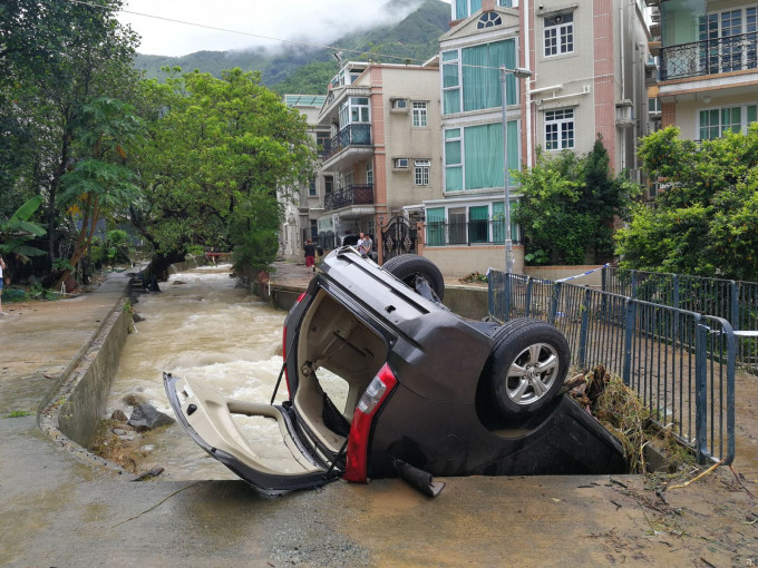 私家車被洪水沖到石橋下。