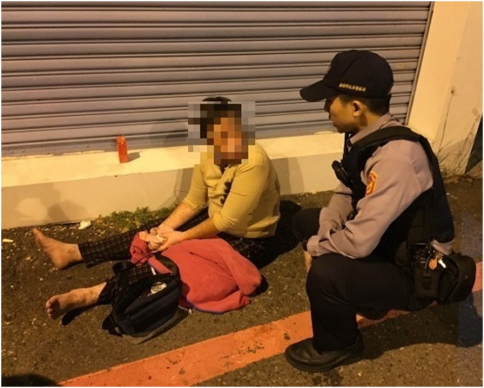 警員向呆坐街頭的鄭婦查問。網圖