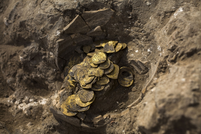 以色列中部城市亚夫内一处考古遗址，挖到一个神秘陶罐藏有425枚千年金币。AP图片