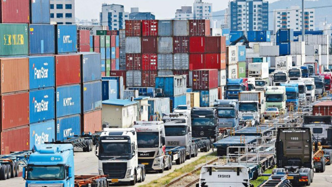 南韓京畿道義王陸路貨櫃中轉站周一泊滿罷工司機的貨車，貨櫃堆積如山。
