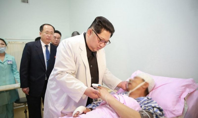 北韓領導人金正恩親赴醫院，緊捉中國傷者手，表示慰問。（網圖）