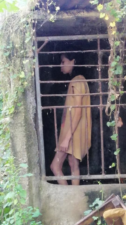 女子獨自一人在鐵籠內對著牆壁喃喃自語。（FB圖片）