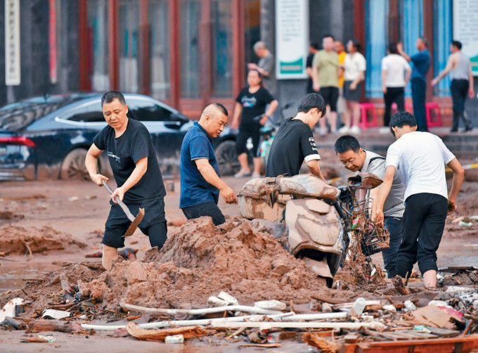 寶雞市民在某路段清理淤泥。