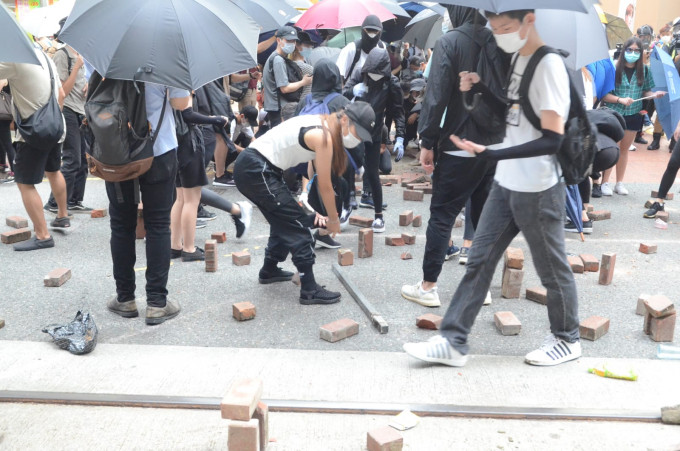 示威者掘起砖头投掷到马路。