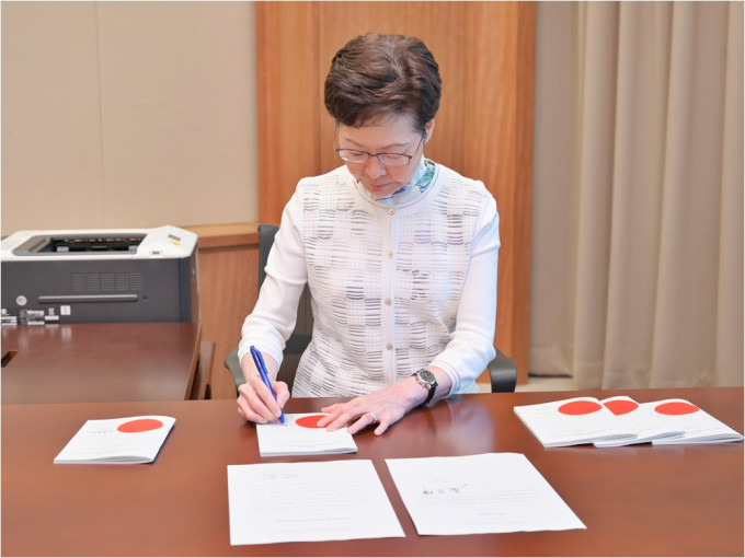 林鄭月娥簽署《2021年公職（參選及任職）（雜項修訂）條例》。政府圖片