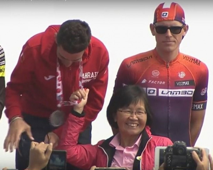 台湾昨日举行「自行车登山王挑战赛」，观光局副局长陈淑慧颁奖时扯著冠军车手尼巴利颈上的奖牌。网图