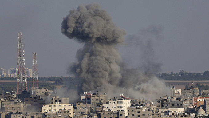 加沙有住宅樓宇受以軍的空襲波及，冒出大量濃煙。AP