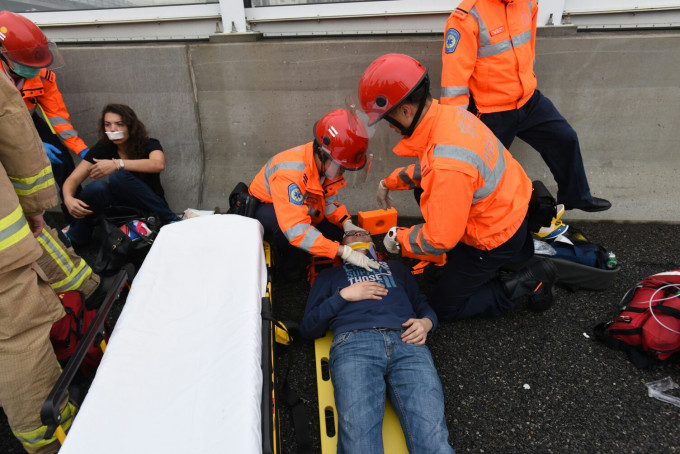 两名男司机需由救护车送往广华医院治理，需先在长板固定。