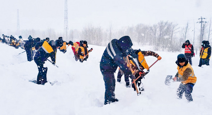 內蒙古赤峰一條鐵路被雪覆蓋，工人合力清雪。