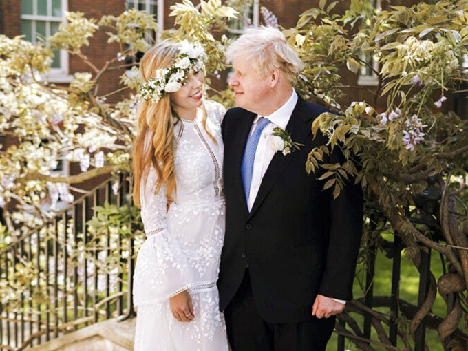 英国首相约翰逊上周六与未婚妻西蒙兹秘密完婚，新娘身穿的象牙色蕾丝婚纱成为外界焦点。AP图片