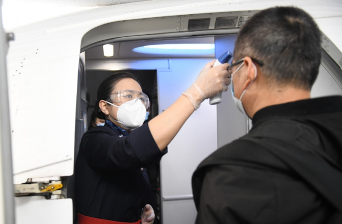 在武漢天河國際機場，乘坐航班的旅客登機前接受體溫檢測。（新華社圖片）