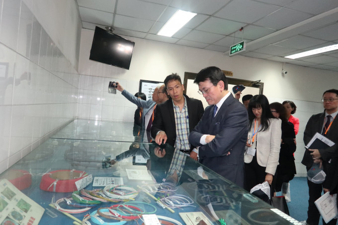 邱騰華（左五）與代表團成員到訪胡志明市出口加工及工業區管理局期間，參觀一間汽車零部件工廠。政府新聞處