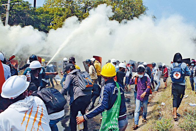首都内比都警察周一发射催泪弹驱散示威者，示威者喷灭火筒还击。