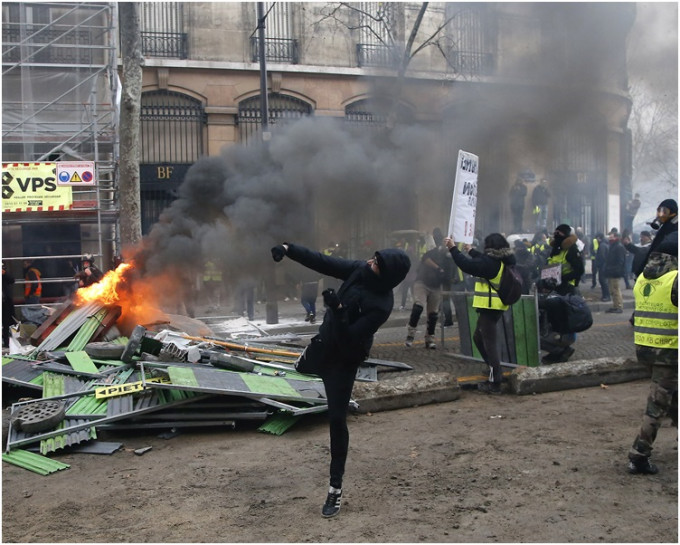 示威者设置临时路障点火烧杂物向防暴警察投掷物件。AP